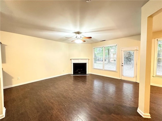 unfurnished living room featuring ceiling fan and dark hardwood / wood-style flooring