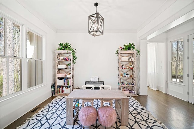 office space featuring dark wood-type flooring, a wealth of natural light, and an inviting chandelier