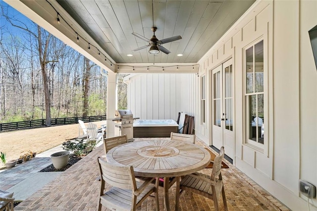 view of patio featuring french doors, fence, a ceiling fan, outdoor dining space, and area for grilling