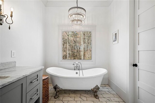 full bath featuring a chandelier, a soaking tub, and vanity