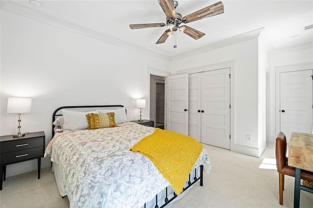 bedroom featuring light colored carpet, a ceiling fan, visible vents, and a closet