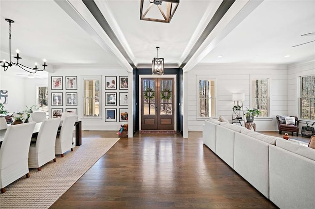 foyer with crown molding, a chandelier, and dark wood finished floors