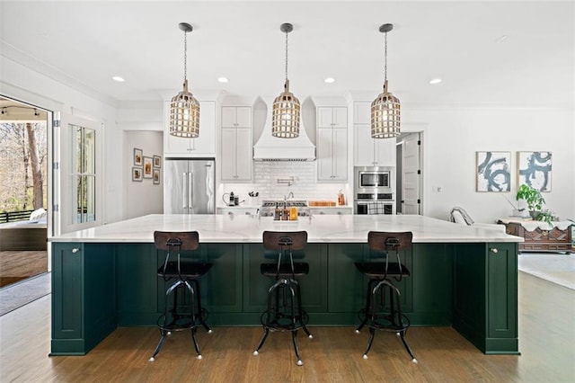 kitchen featuring white cabinetry, custom range hood, stainless steel appliances, and an inviting chandelier