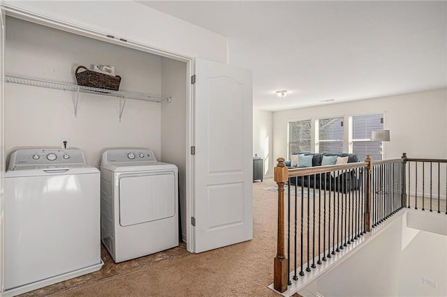 laundry room featuring laundry area, separate washer and dryer, and light colored carpet