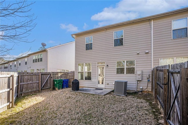 back of house featuring a patio area, a fenced backyard, a lawn, and central AC unit