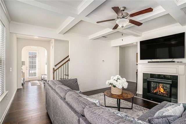 living room featuring a tile fireplace, coffered ceiling, baseboards, stairs, and dark wood finished floors