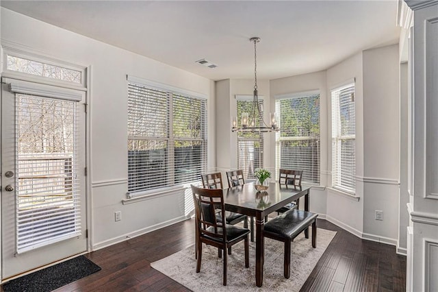 dining area featuring baseboards, visible vents, a chandelier, and dark wood-style flooring