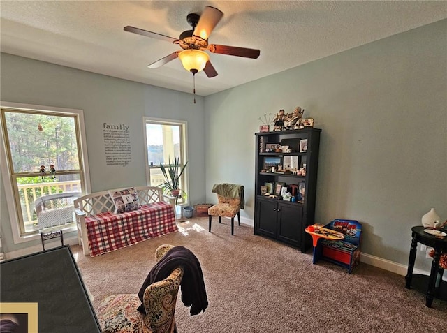 interior space with ceiling fan, a textured ceiling, and carpet flooring