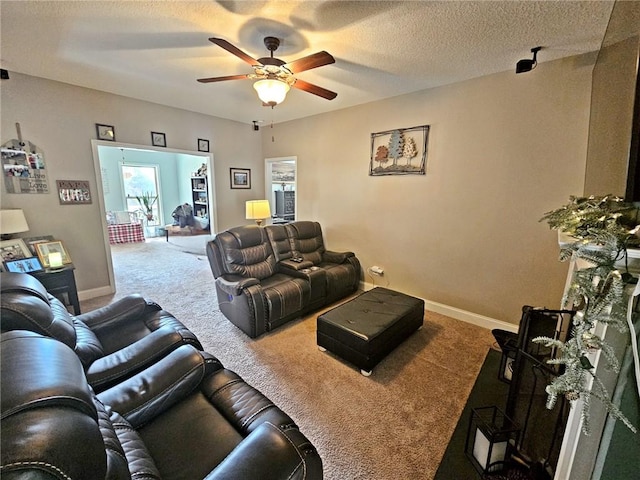 living room featuring ceiling fan, carpet floors, and a textured ceiling