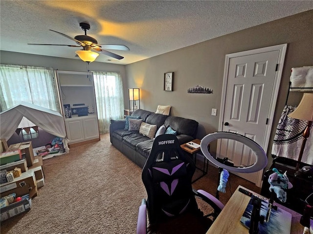 carpeted living room featuring ceiling fan and a textured ceiling