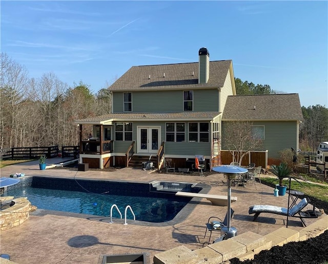 back of house featuring a pool with hot tub, a patio area, and french doors