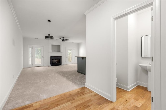 90 Grove Park Ln, Woodstock, GA 30189 - unfurnished living room featuring ceiling fan, baseboards, a fireplace with flush hearth, ornamental molding, and wood finished floors