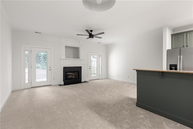 90 Grove Park Ln, Woodstock, GA 30189 - unfurnished living room featuring light colored carpet, healthy amount of natural light, ceiling fan, baseboards, and ornamental molding