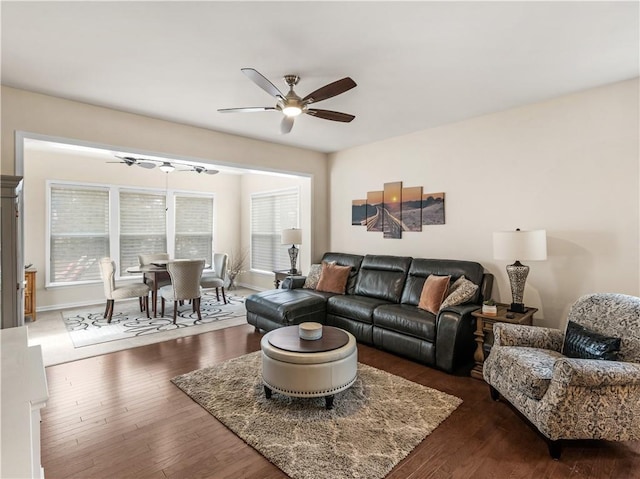 living area featuring ceiling fan and dark wood-style floors