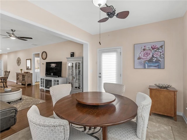 dining room with light wood-style floors, baseboards, and ceiling fan