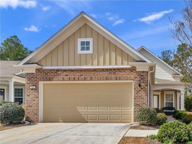 view of front facade with a garage, brick siding, board and batten siding, and driveway