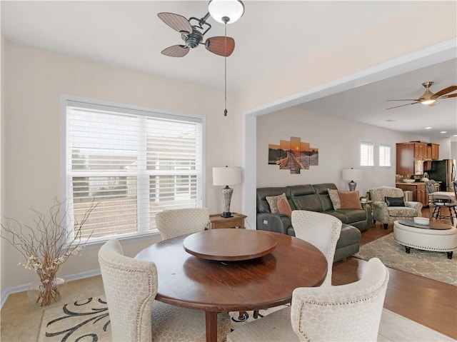 dining room with baseboards, light wood-style flooring, and a ceiling fan