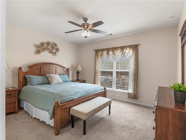 bedroom featuring visible vents, light colored carpet, baseboards, and ceiling fan