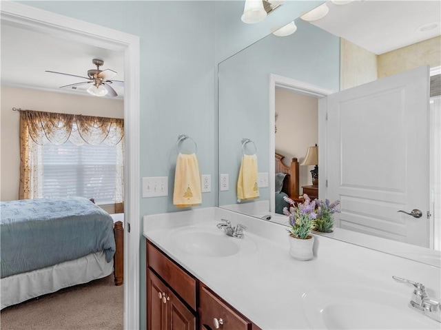 ensuite bathroom with a sink, connected bathroom, ceiling fan, and double vanity