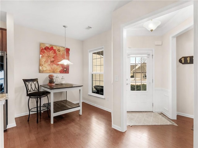 foyer entrance featuring hardwood / wood-style flooring, baseboards, and visible vents