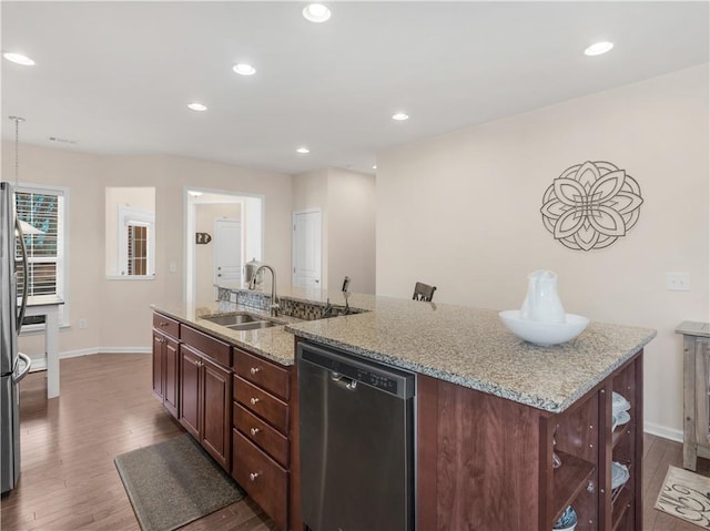 kitchen with wood finished floors, a center island with sink, recessed lighting, a sink, and stainless steel appliances