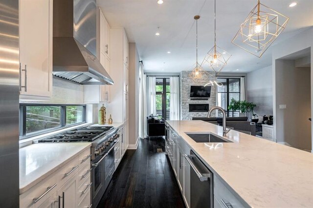 kitchen with white cabinetry, dark wood-type flooring, sink, and wall chimney range hood