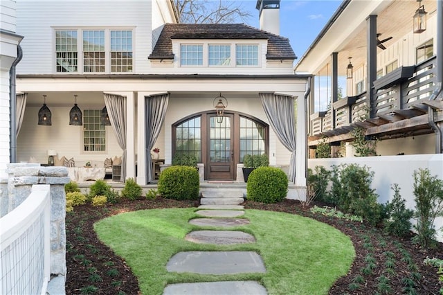 doorway to property featuring covered porch and a chimney