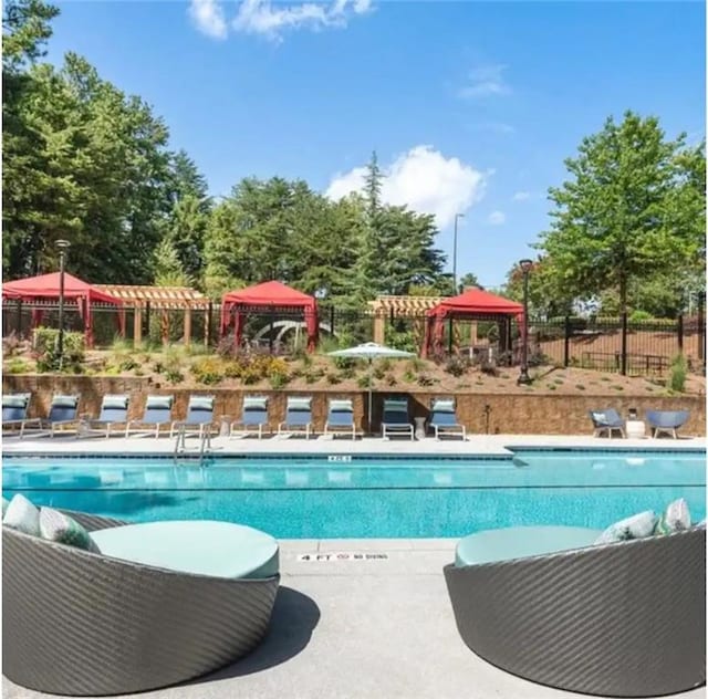 community pool with fence and a gazebo