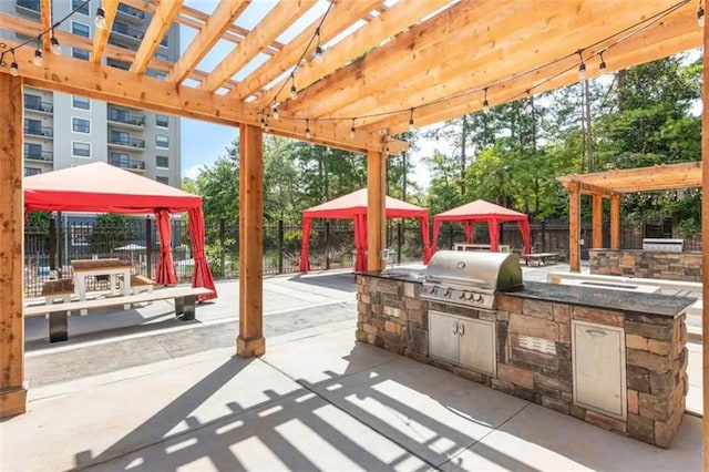 view of patio / terrace with area for grilling, fence, a gazebo, grilling area, and a pergola