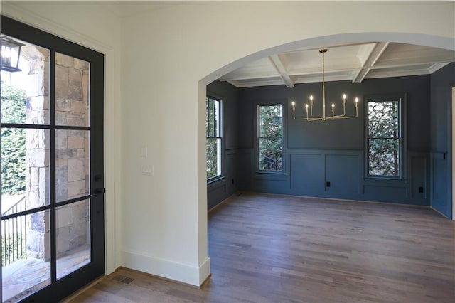 entrance foyer with coffered ceiling, hardwood / wood-style flooring, beamed ceiling, and an inviting chandelier