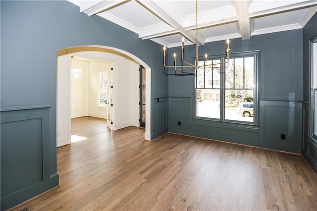 unfurnished dining area with hardwood / wood-style flooring, coffered ceiling, beam ceiling, and crown molding