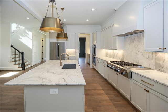 kitchen with premium range hood, an island with sink, appliances with stainless steel finishes, and sink