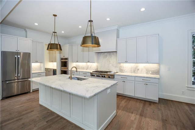 kitchen featuring tasteful backsplash, an island with sink, sink, stainless steel appliances, and light stone countertops