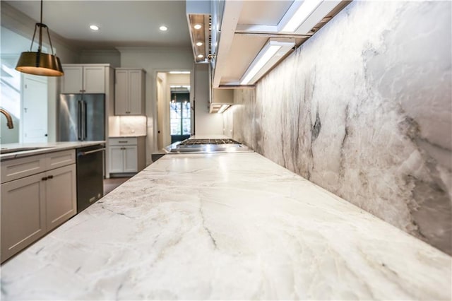 kitchen with sink, gray cabinetry, decorative light fixtures, appliances with stainless steel finishes, and light stone countertops