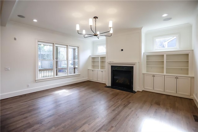 unfurnished living room with dark hardwood / wood-style flooring, a notable chandelier, and ornamental molding