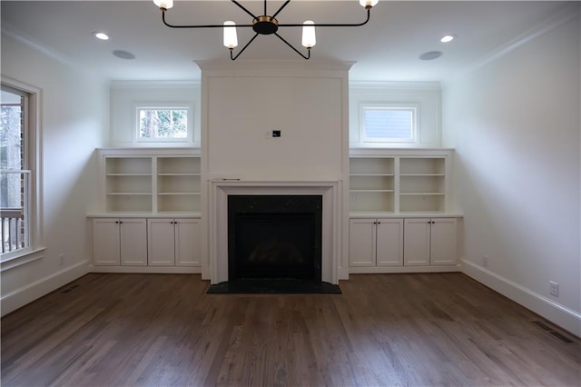 unfurnished living room featuring ornamental molding, dark hardwood / wood-style flooring, and a notable chandelier