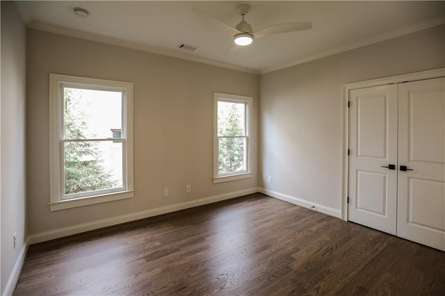 unfurnished bedroom featuring ornamental molding, dark hardwood / wood-style floors, ceiling fan, and a closet