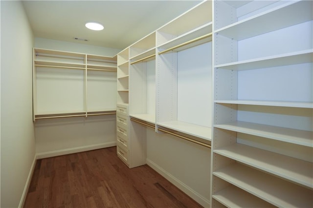 walk in closet with dark wood-type flooring