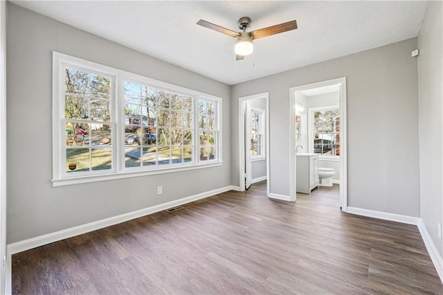 unfurnished room with dark wood-type flooring and ceiling fan