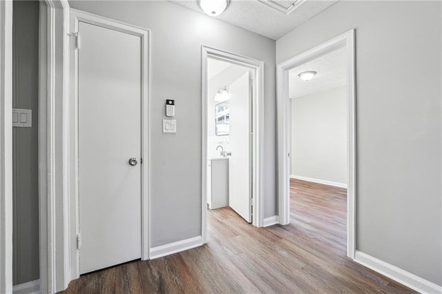 hallway with wood-type flooring and a textured ceiling