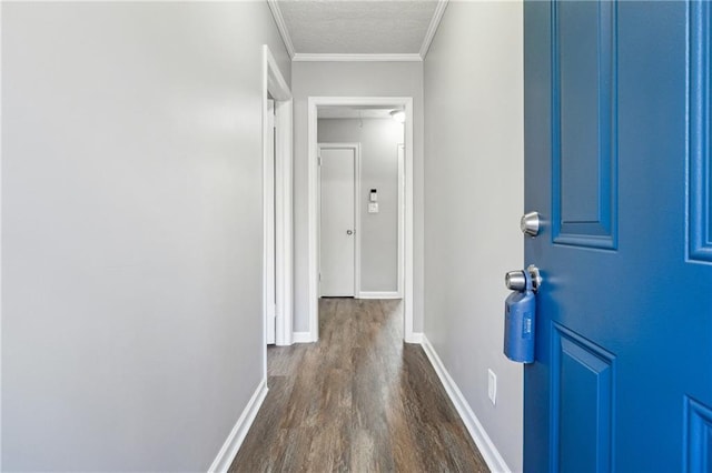 hall featuring a textured ceiling, dark wood-type flooring, and crown molding