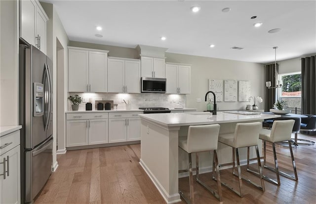 4297 Azalea Ridge Way, Hoschton, GA 30548 - kitchen featuring appliances with stainless steel finishes, a sink, light wood-type flooring, light countertops, and recessed lighting
