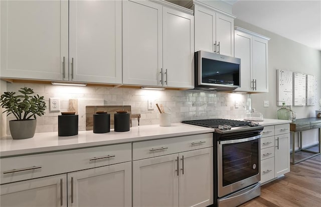 4297 Azalea Ridge Way, Hoschton, GA 30548 - kitchen featuring stainless steel appliances, light countertops, light wood-type flooring, tasteful backsplash, and white cabinetry