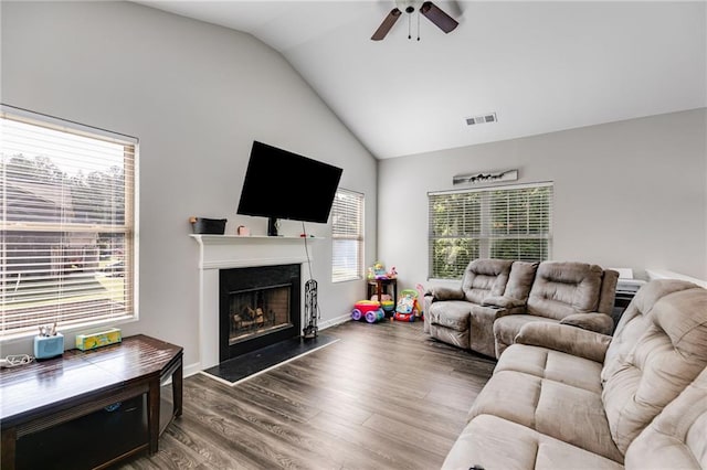 119 Sourwood Ln, Temple, GA 30179 - living room featuring a fireplace with raised hearth, a ceiling fan, wood finished floors, vaulted ceiling, and visible vents