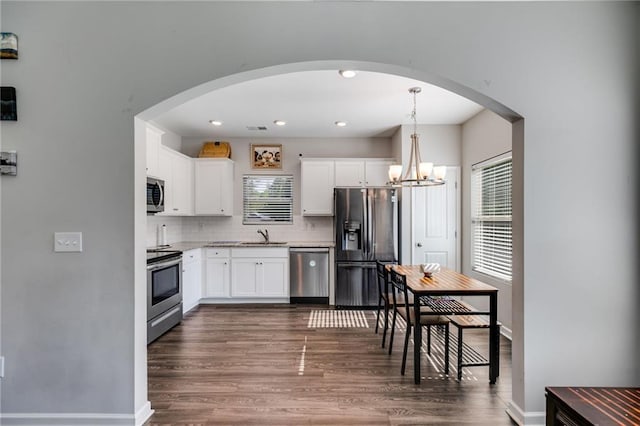 119 Sourwood Ln, Temple, GA 30179 - kitchen featuring backsplash, stainless steel appliances, dark wood finished floors, and white cabinetry