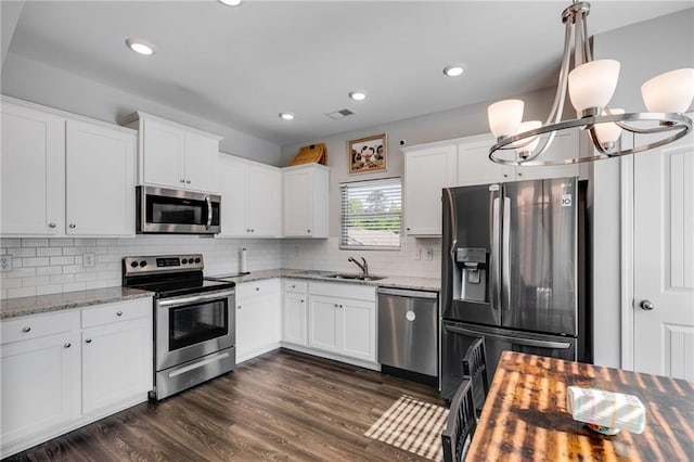 119 Sourwood Ln, Temple, GA 30179 - kitchen with white cabinets, appliances with stainless steel finishes, tasteful backsplash, visible vents, and dark wood-style floors