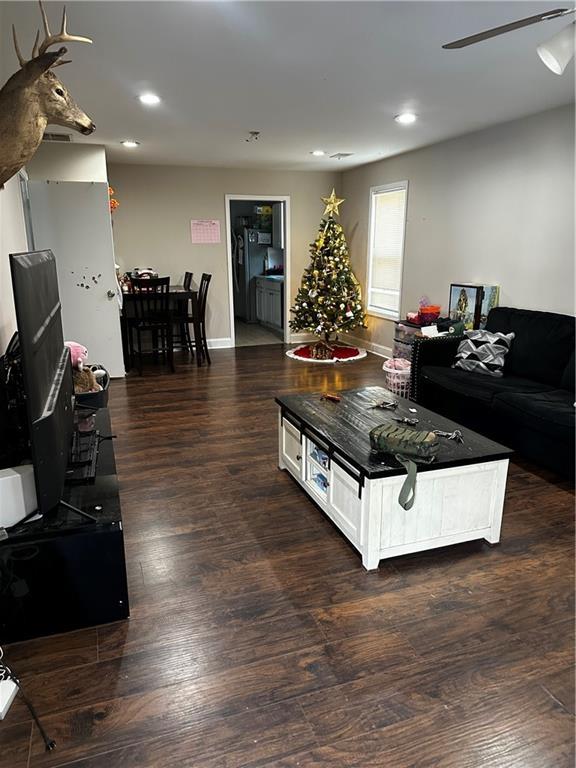 living room with dark wood-type flooring and ceiling fan