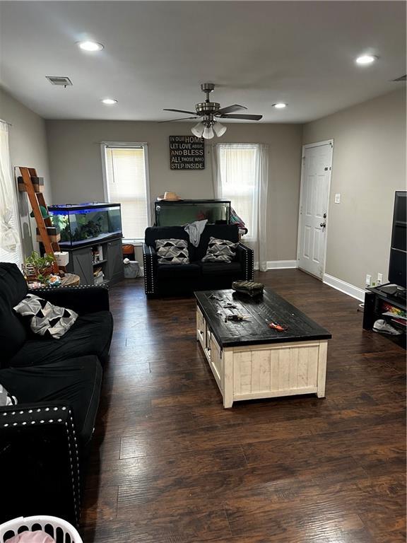 living room featuring dark hardwood / wood-style flooring and ceiling fan