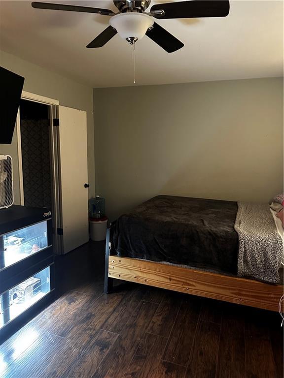 bedroom with dark hardwood / wood-style flooring and ceiling fan