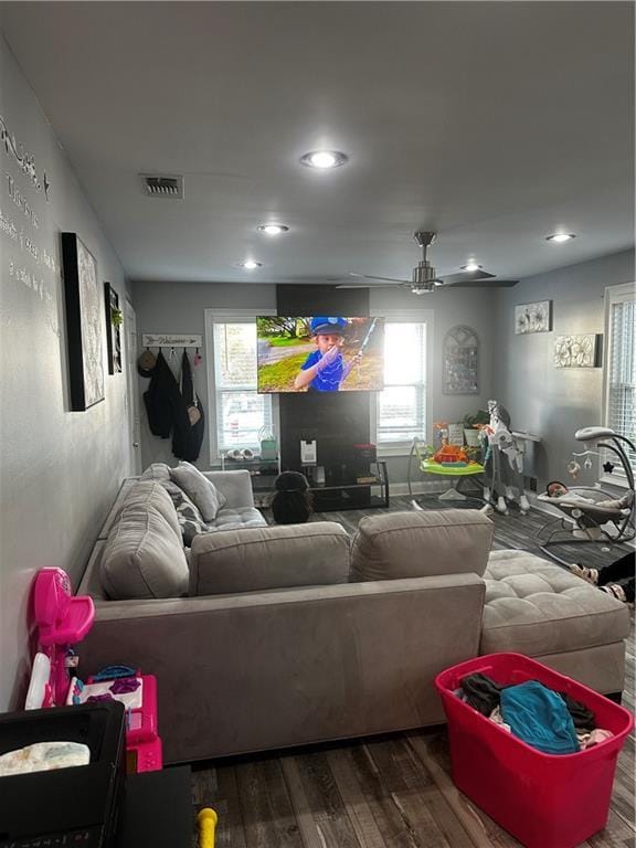 living room with wood-type flooring and ceiling fan